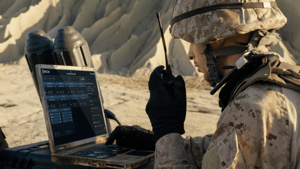 Soldier using laptop with REDCOM C2 Console in desert