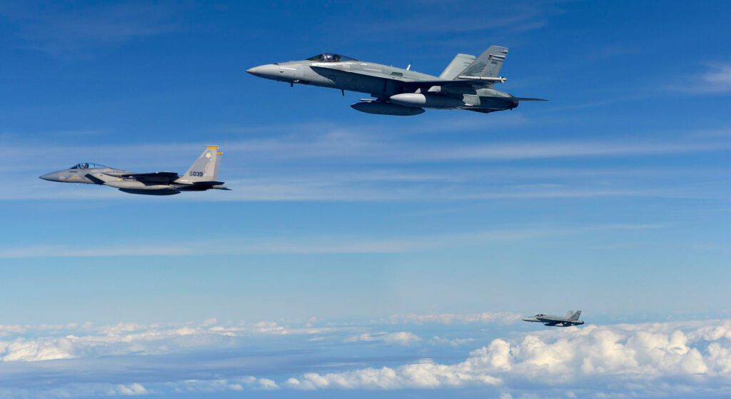 Three Military aircraft above clouds