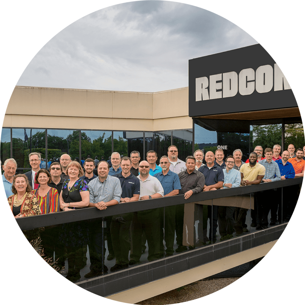 circular photo of REDCOM employees outside of building, who are RIT graduates